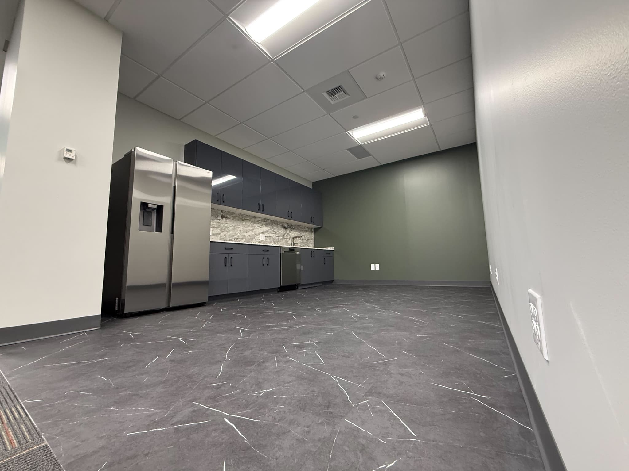 Executive suite break room with stainless steel appliances and marble countertops