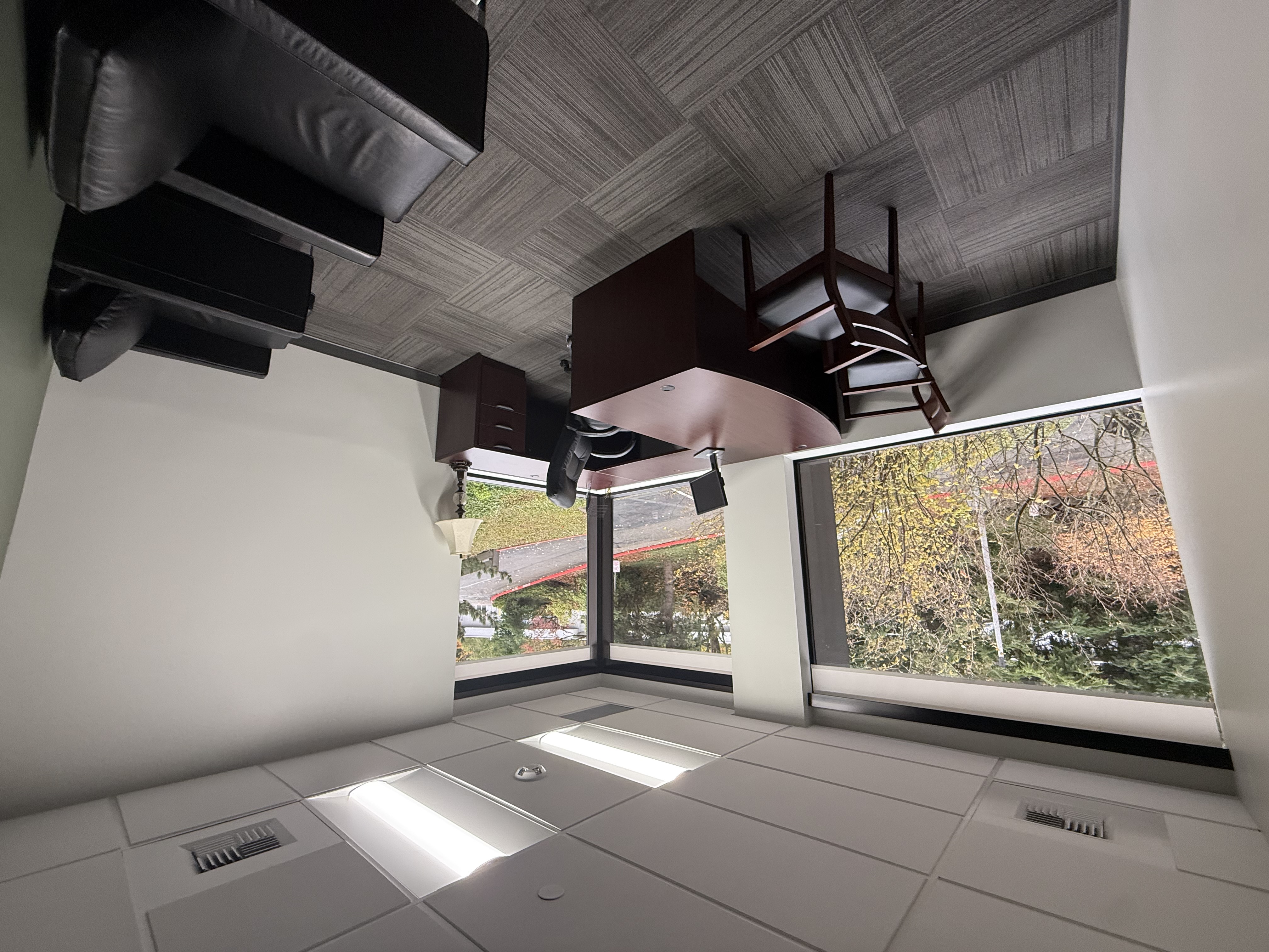 Large corner office with floor-to-ceiling windows and skyline views