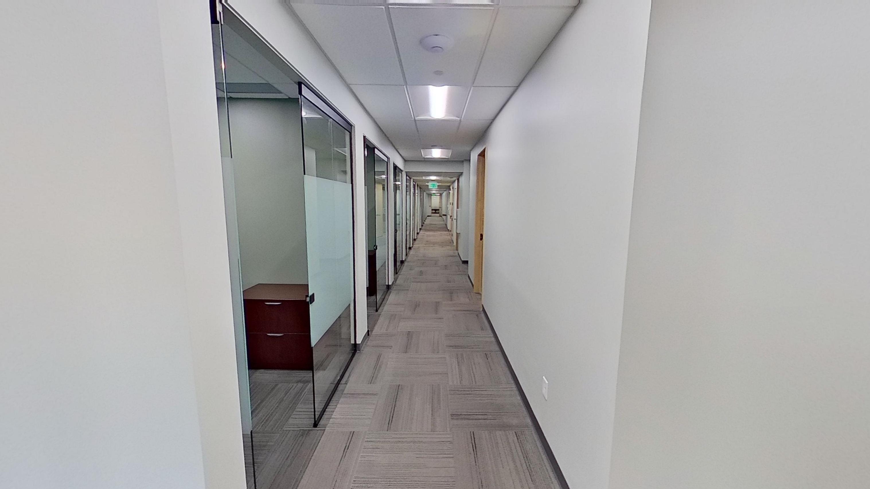 Large conference room with classroom-style seating, natural lighting from windows, and professional setup